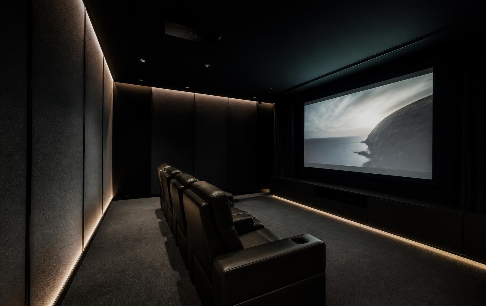 Private home cinema with acoustic fabric walls and concealed linear lighting